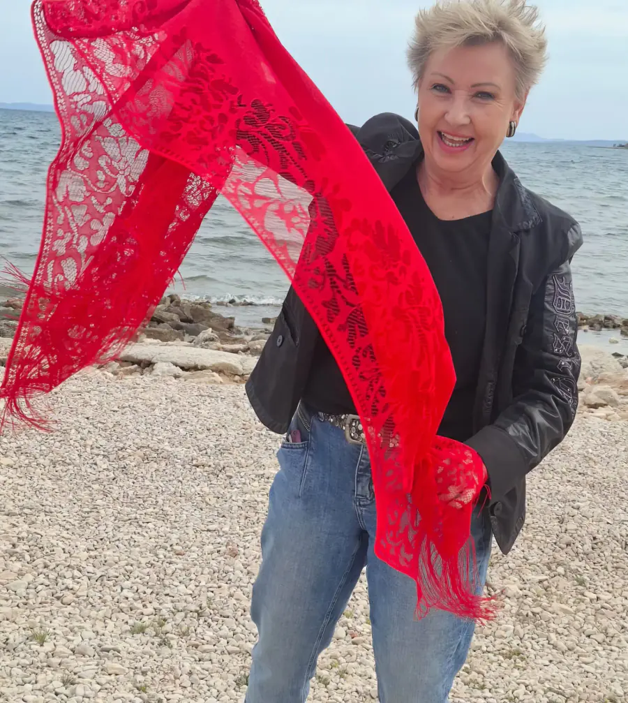 Monika lachend mit rotem Tuch am kroatischen Meer